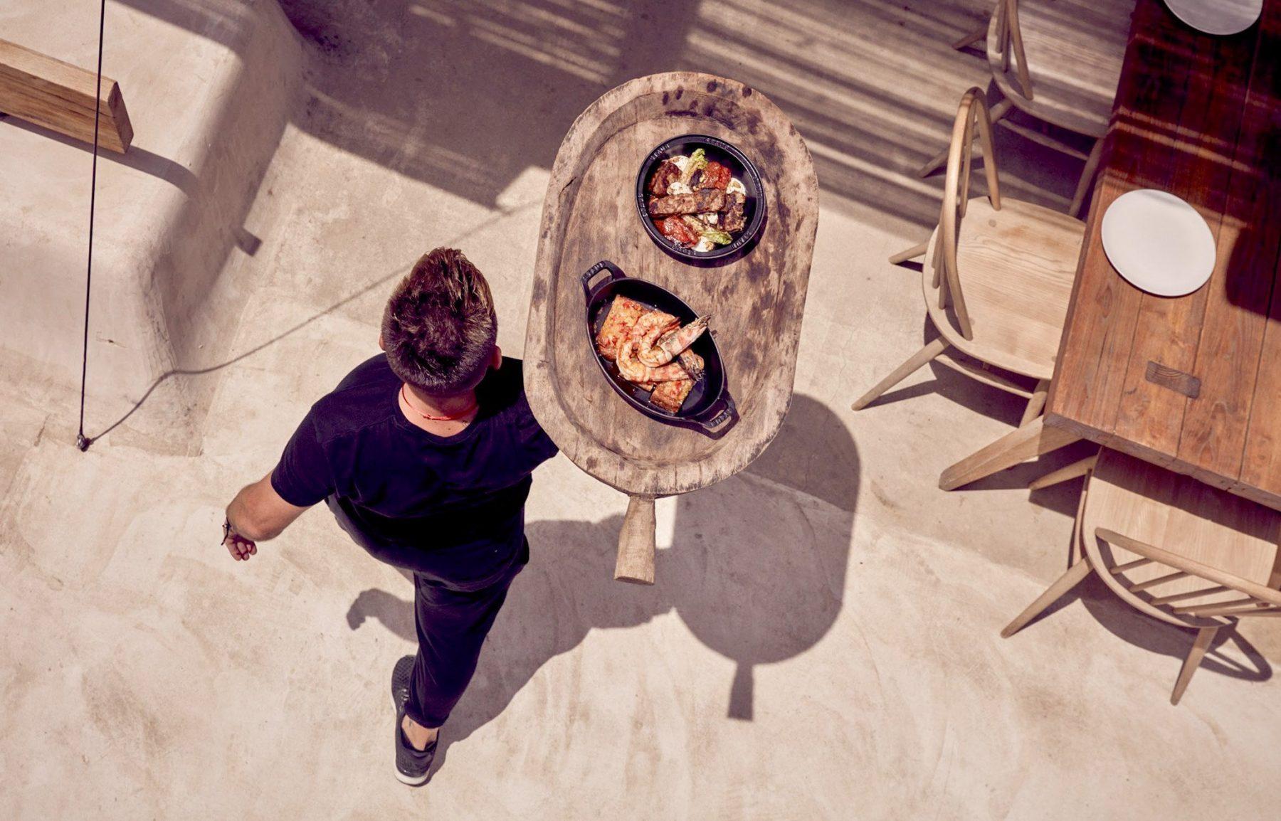 Waiter bringing seafood pictured from above