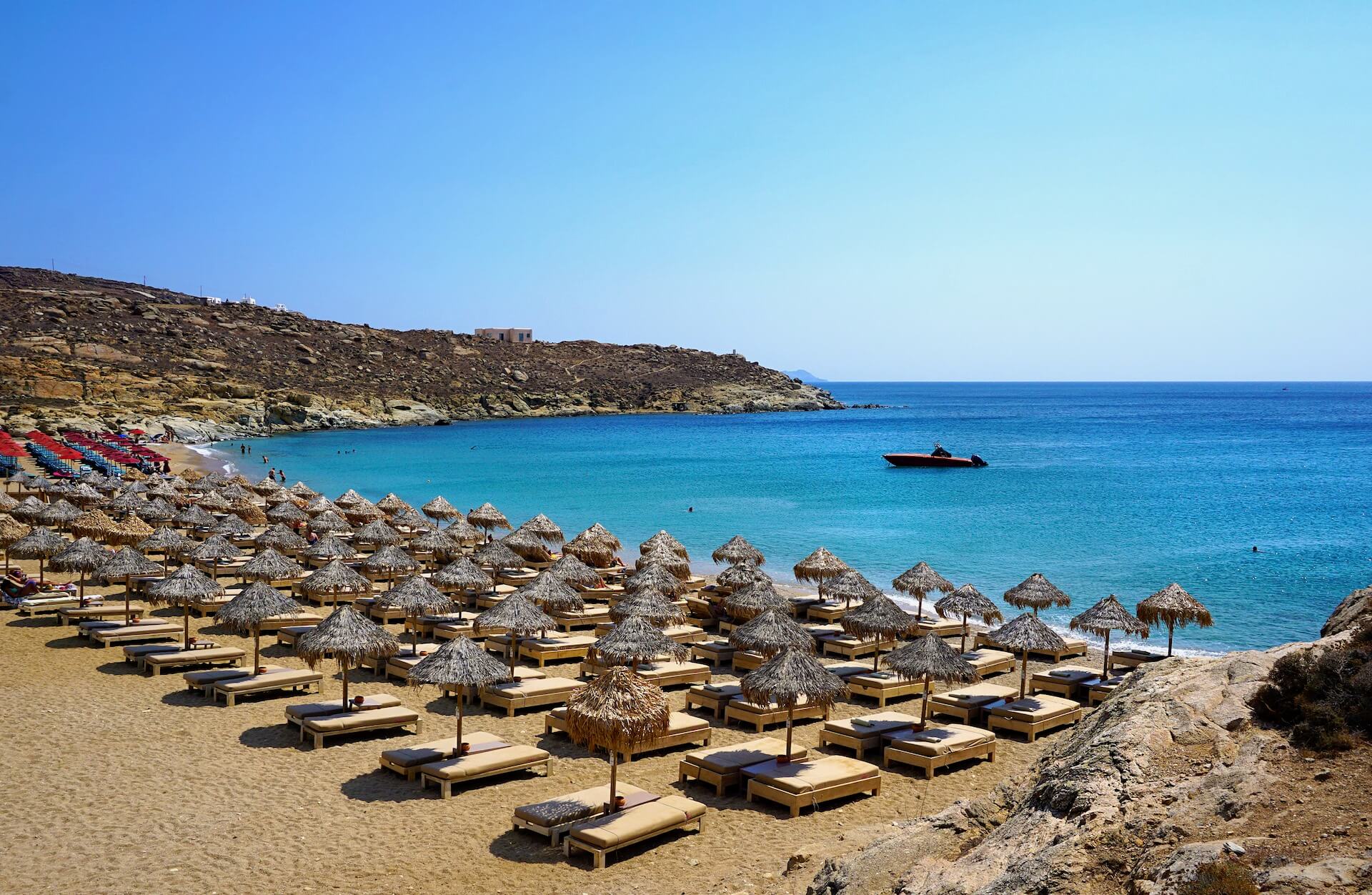 Beach in Mykonos full of sunbeds and umbrellas