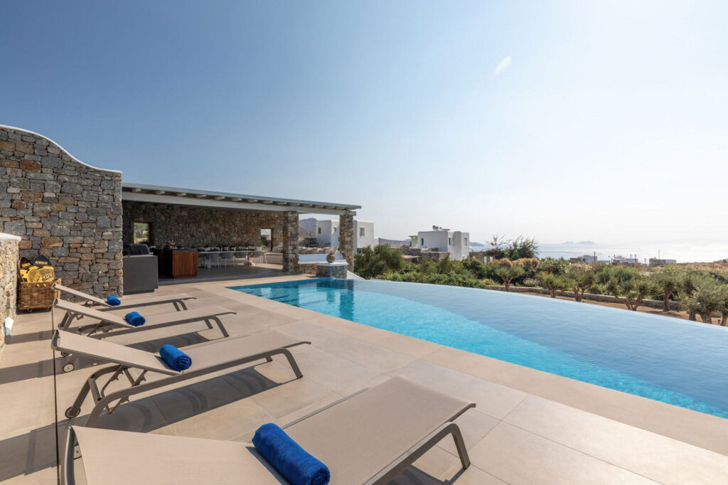 Comfortable sun beds and a luxurious swimming pool in the best villa for rent, Mykonos.