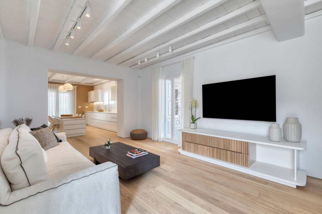 Cozy living room with a wooden floor and white walls in the finest villa for rent, Mykonos.