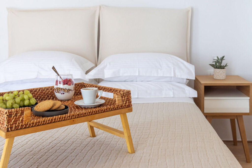 Comfortable bed and a bed tray for a perfect breakfast in the deluxe villa for rent, in Mykonos, Greece.