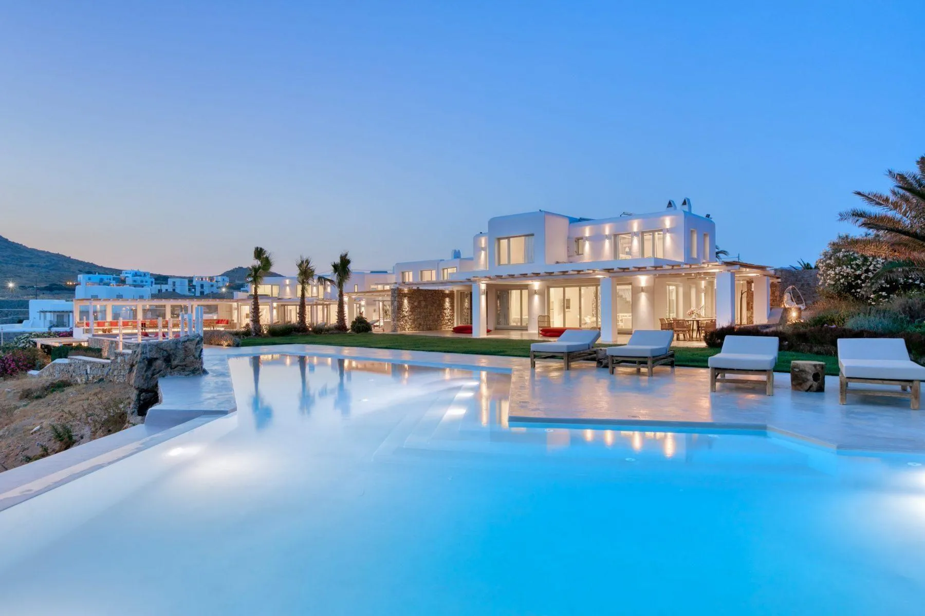 View of the pool and a villa in Mykonos at sunset