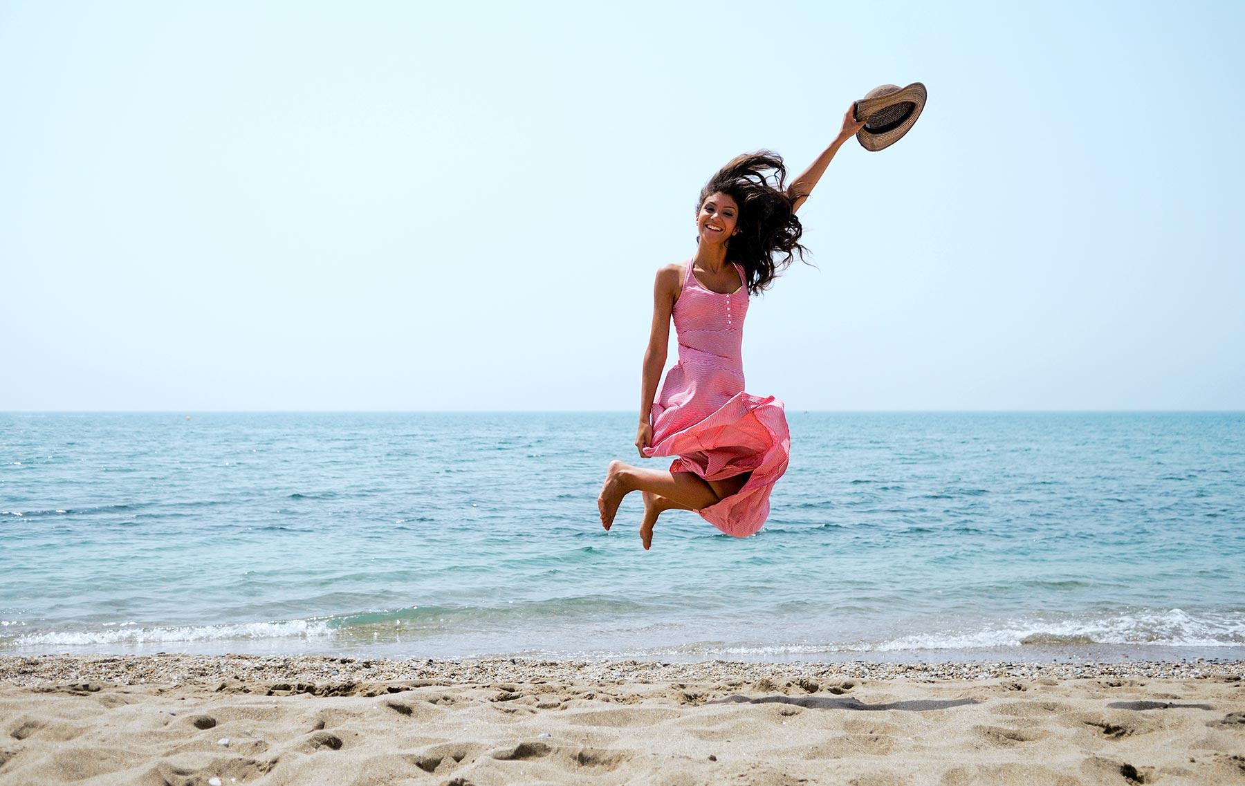 Woman on a beach with a hat