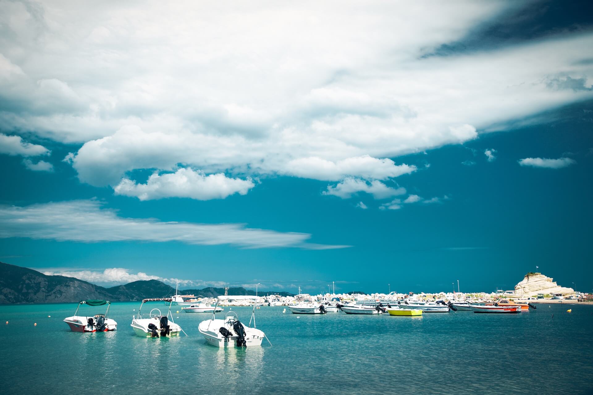 Clouds above the sea filled with boats