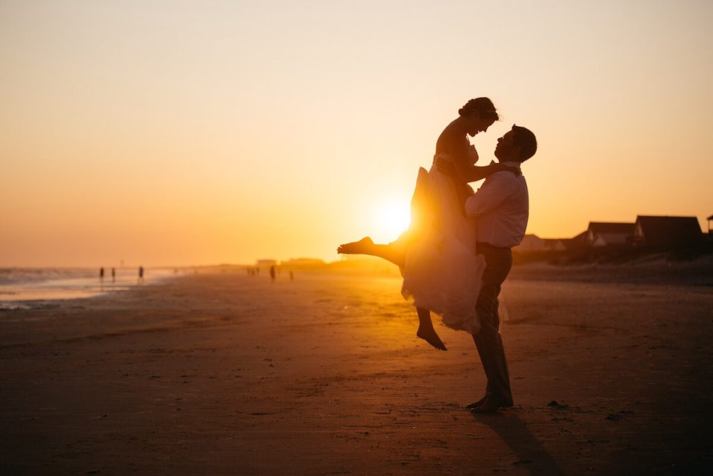 Couple who just got married on the beach during the sunset