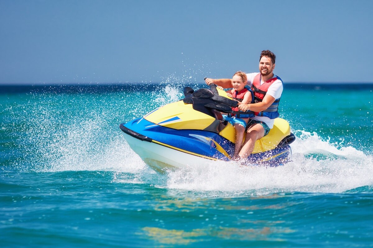 Father and son driving a jet ski