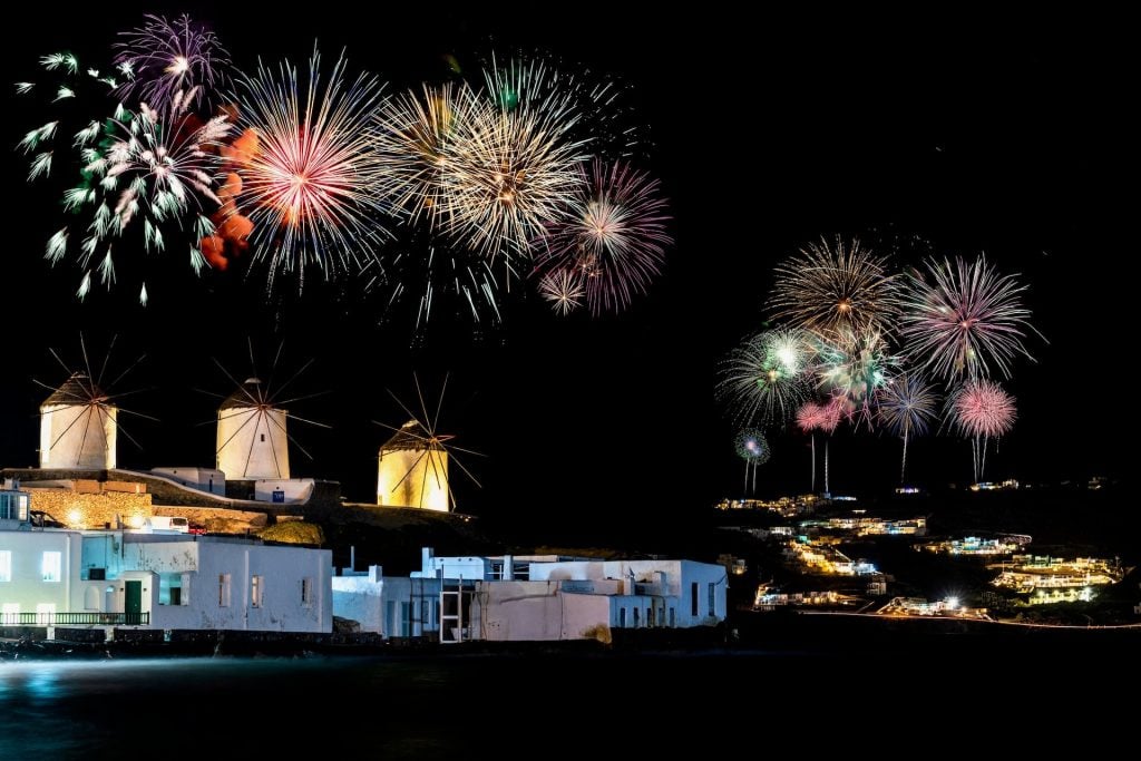 Fireworks over windmills at night