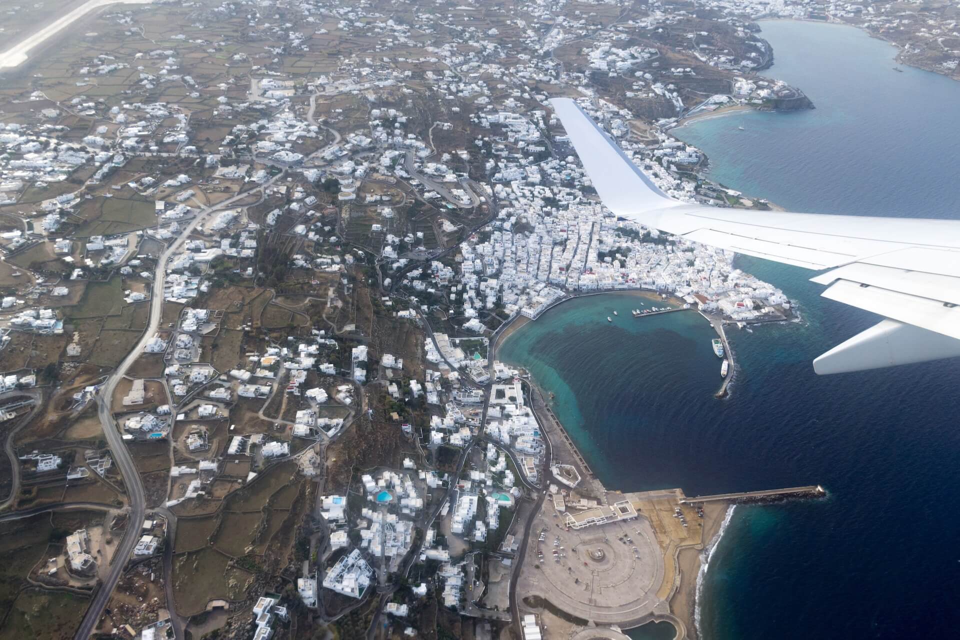 Wing of an airplane above Mykonos coast