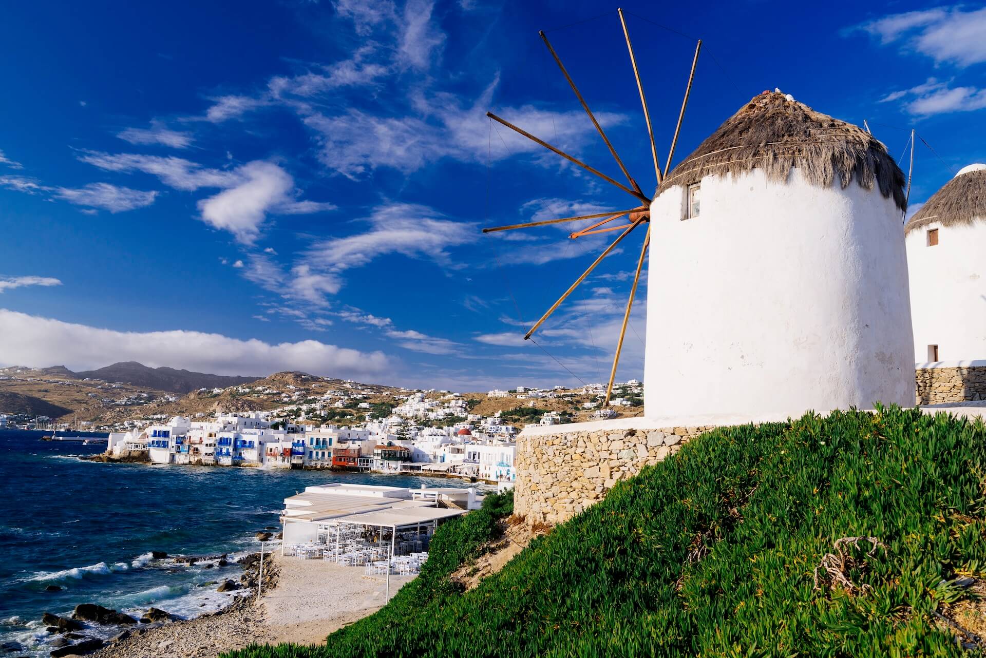 Windmills on the right and a view of Mykonos town on the left