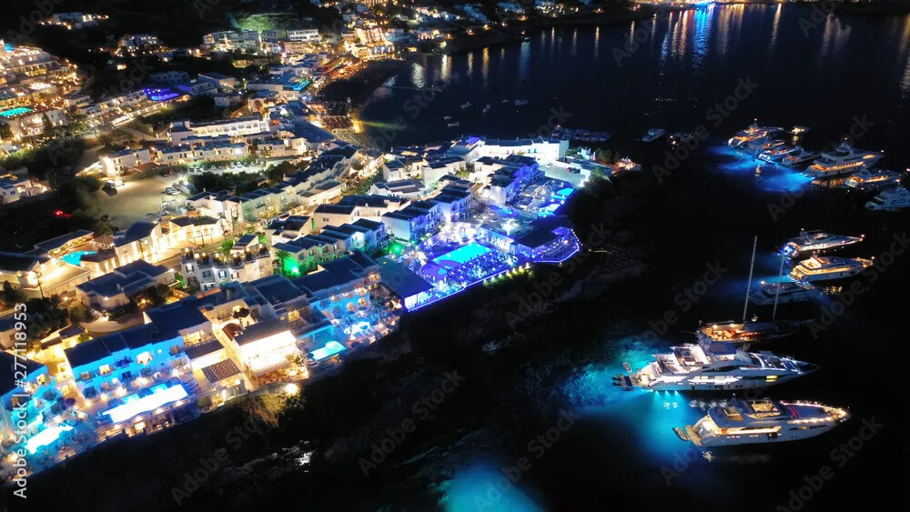 Aerial view of Psarou beach at night and yachts near the coast