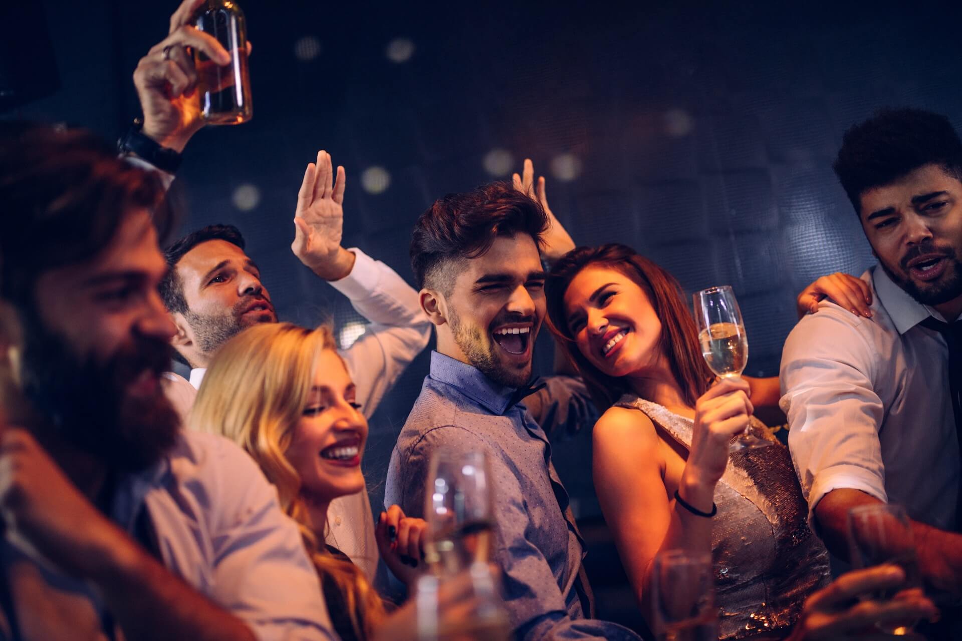 Group of friends dancing and drinking