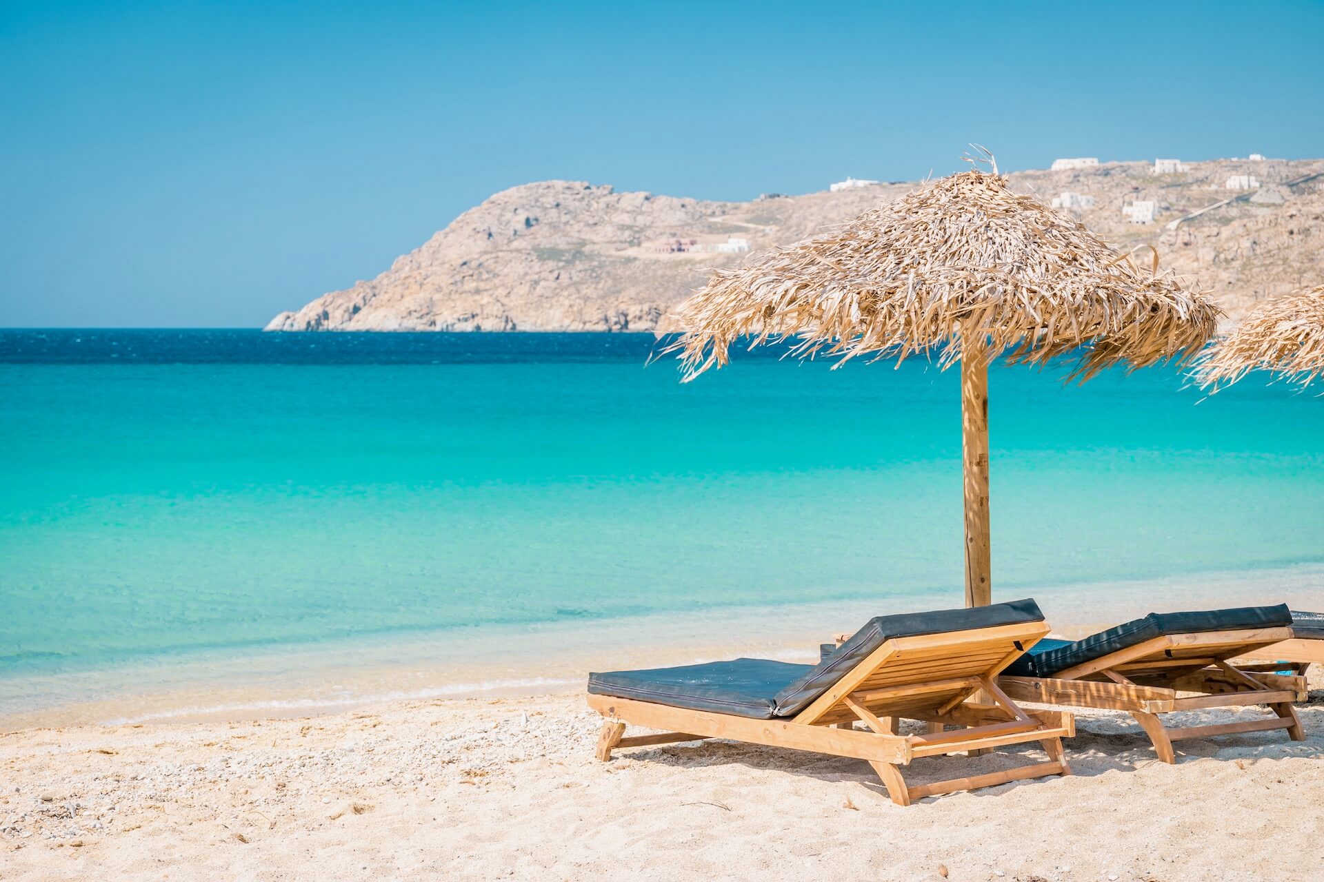 Two sunbeds and parasols on a beach