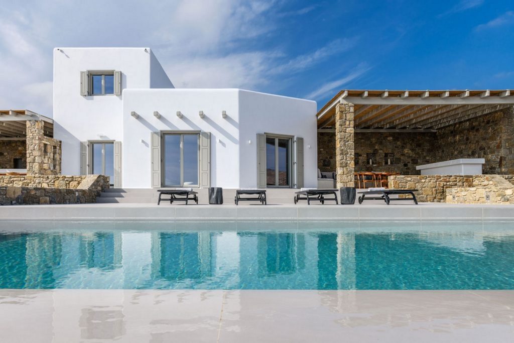 View of the pool in front of a white villa in Mykonos