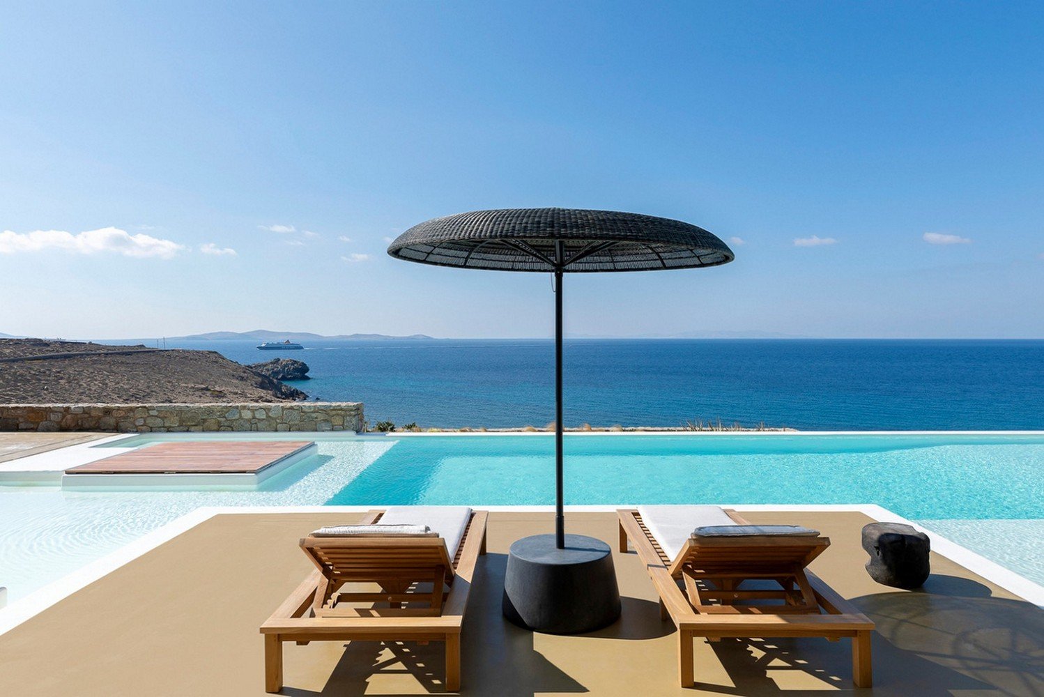 Two wooden sunbeds next to a private pool