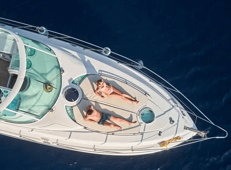 A man and a woman lying on a deck of the yacht
