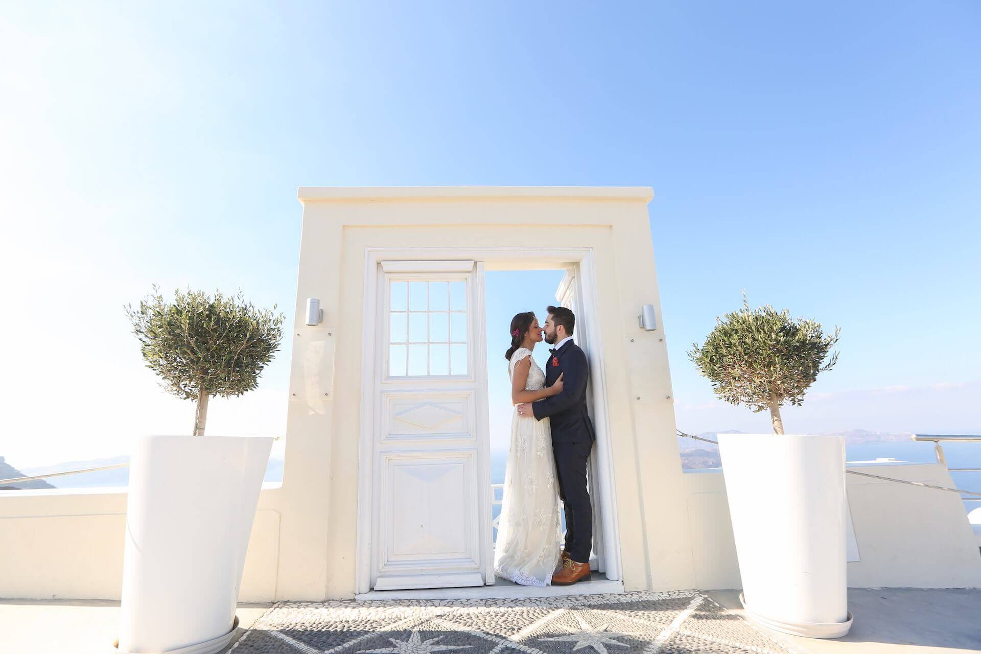 Bride and groom kissing next to the gate in Mykonos