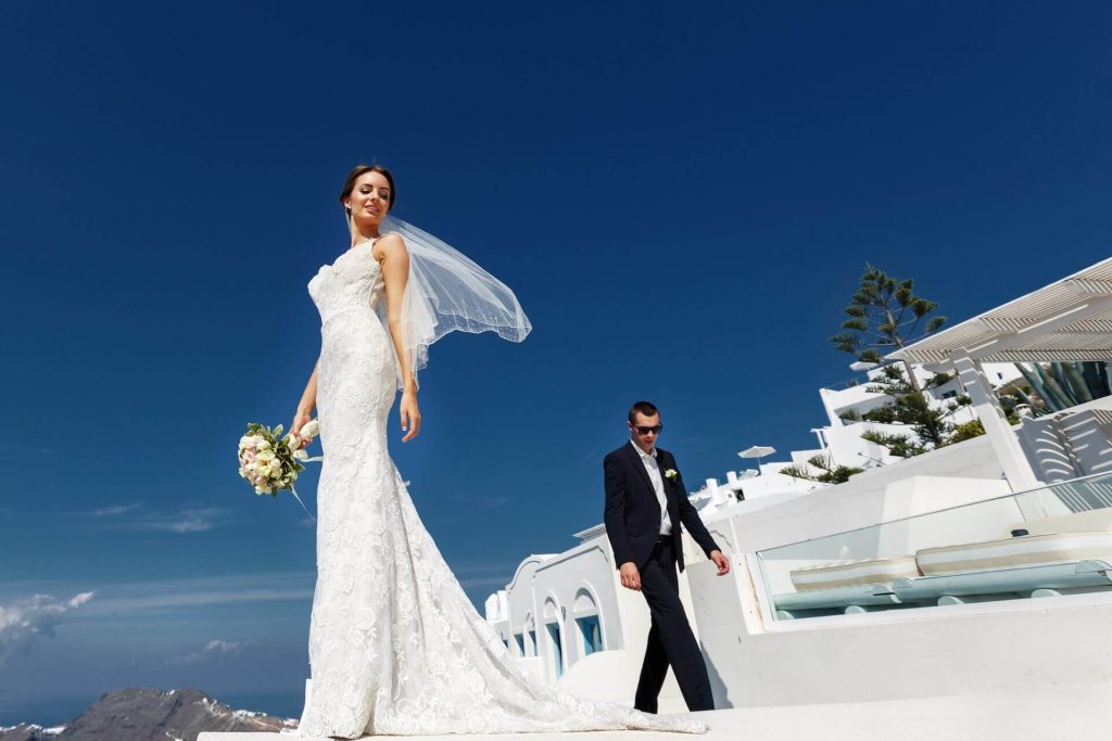 Bride and groom posing on the terrace with a sea view in Mykonos