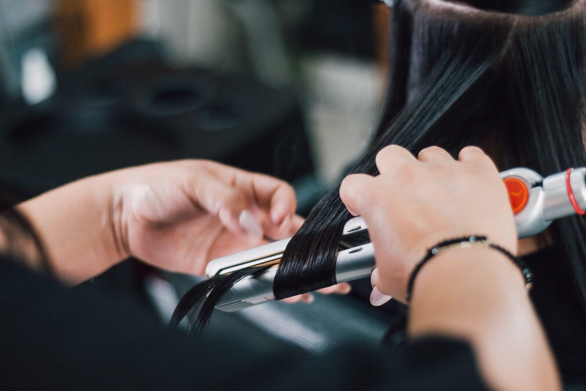 Girl getting her hair straightened at a salon