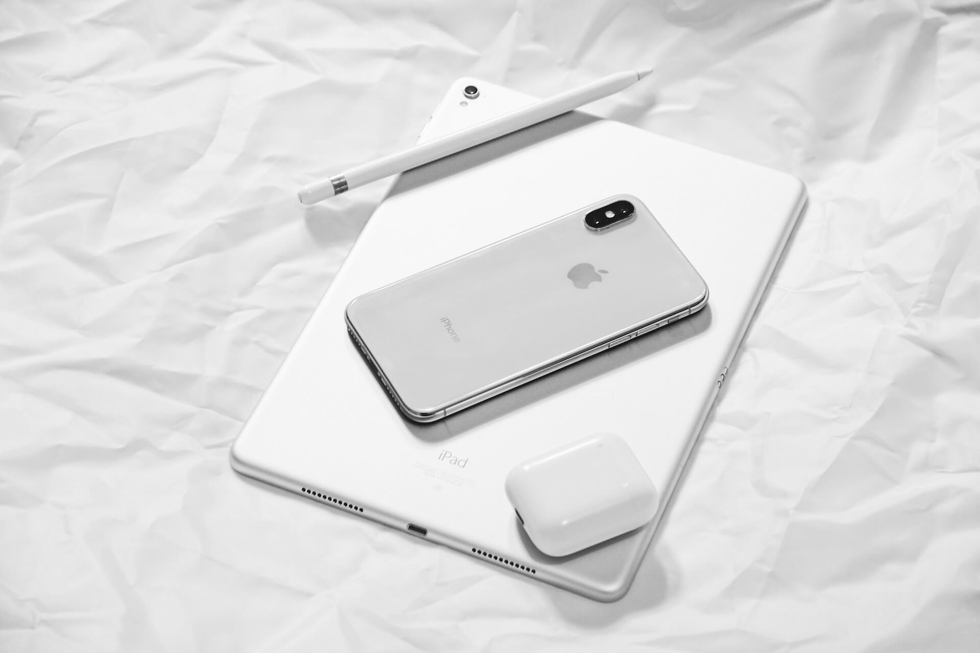 iPhone, iPad, and AirPods on a white surface