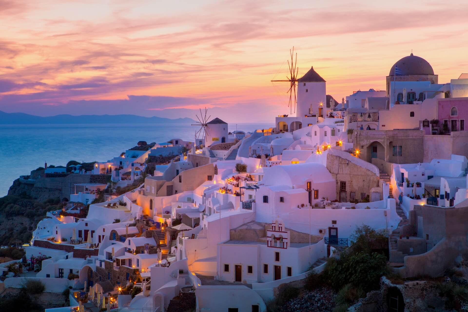 A view of white Mykonian villas in the sunset