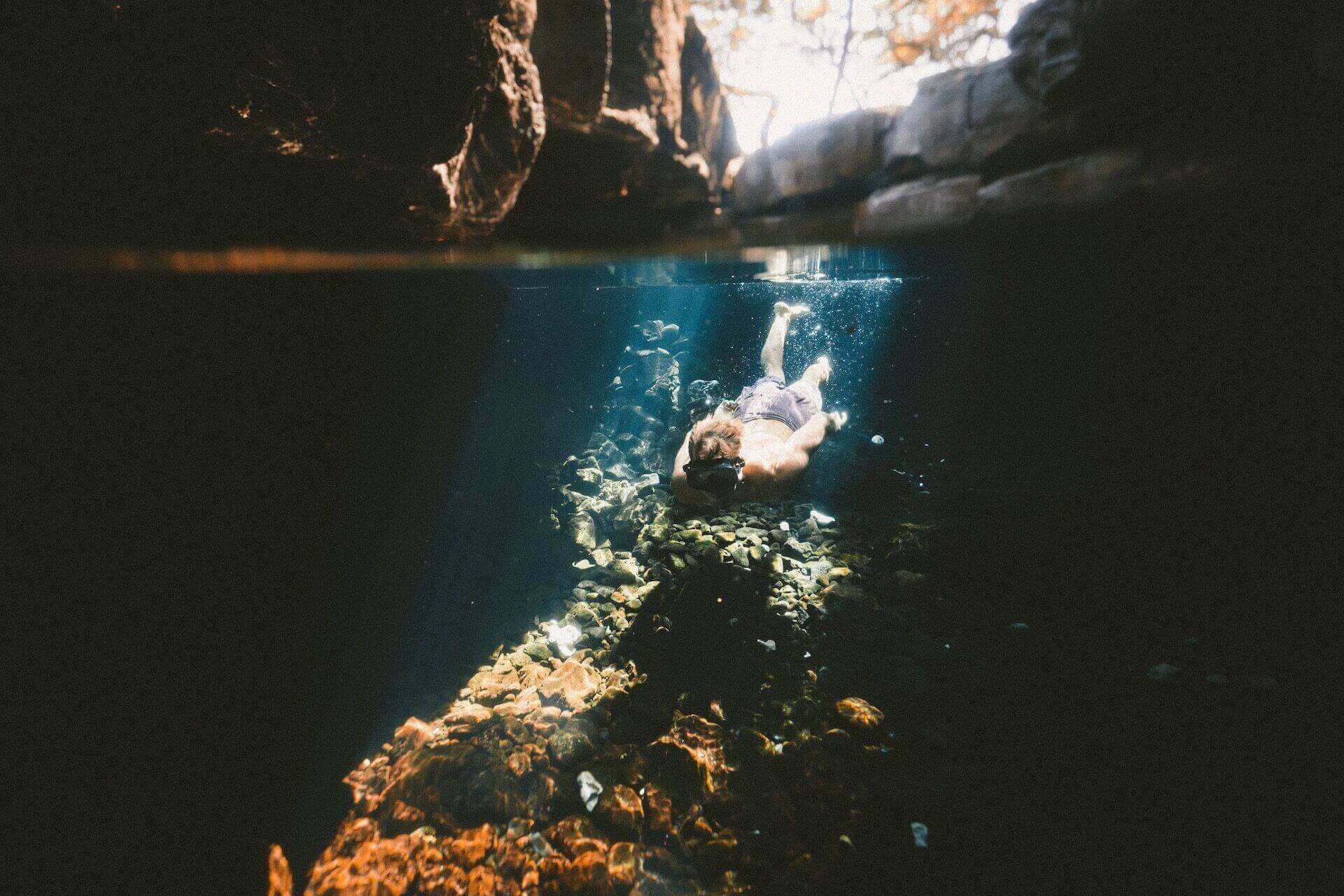 Guy swimming in a Mykonos cave