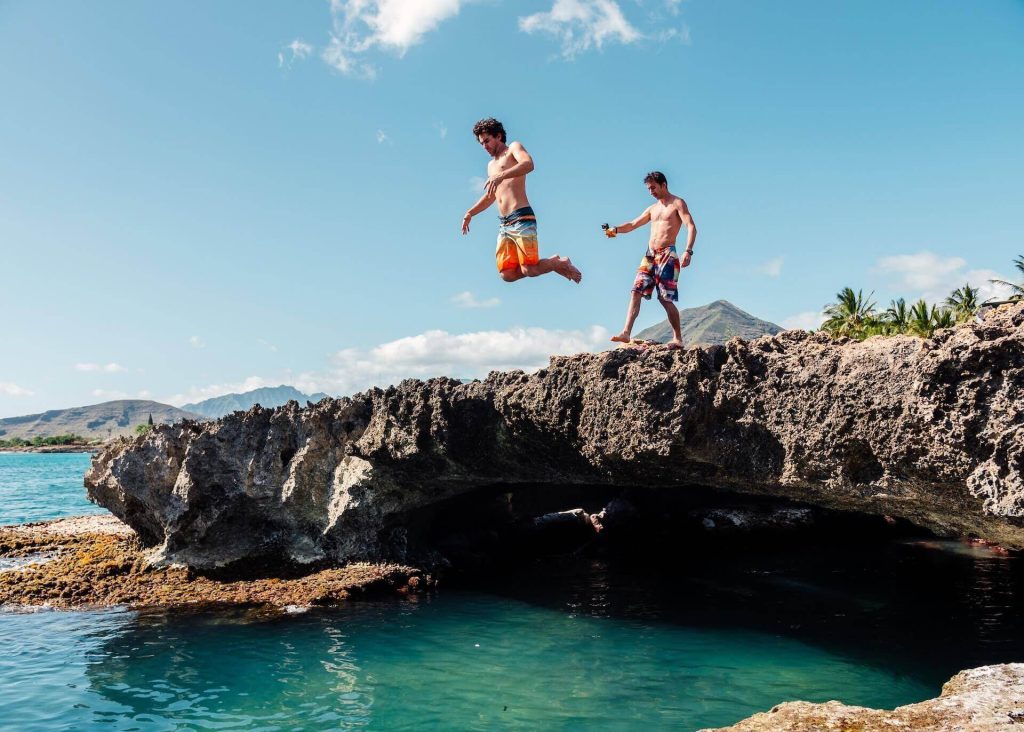 Two guys jumping off a cliff