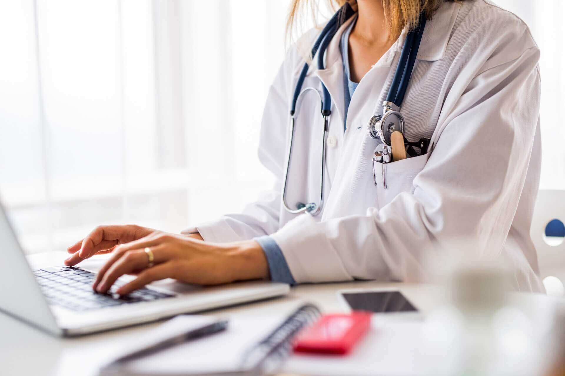 Doctor typing on a computer