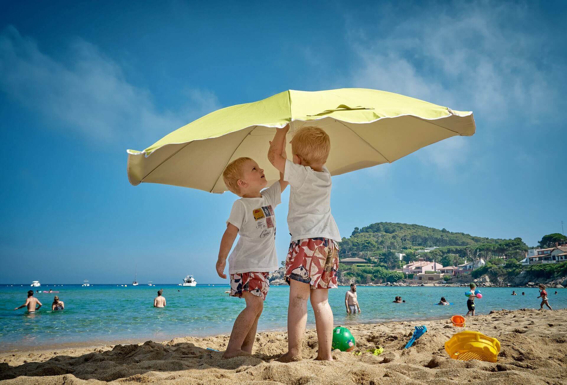 Two boys and a parasol on the beach