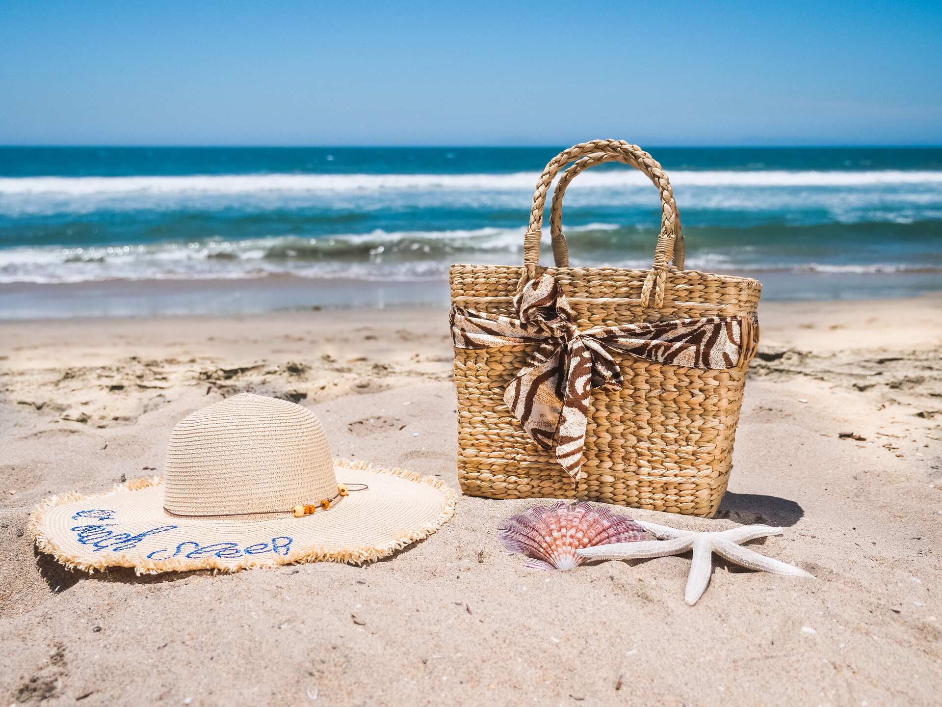 Brown woven bag on a white sand beach