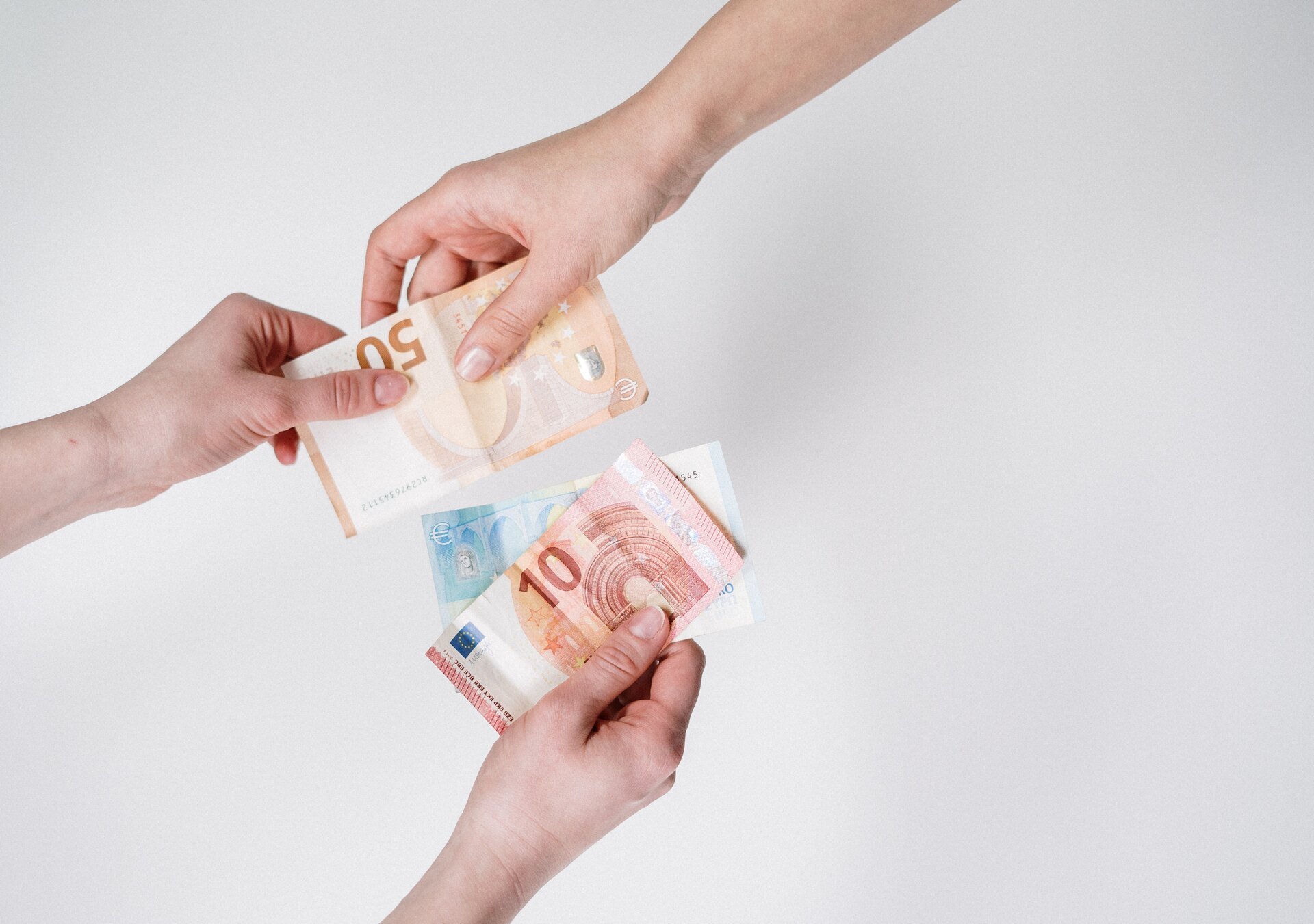 Two people exchanging euro banknotes