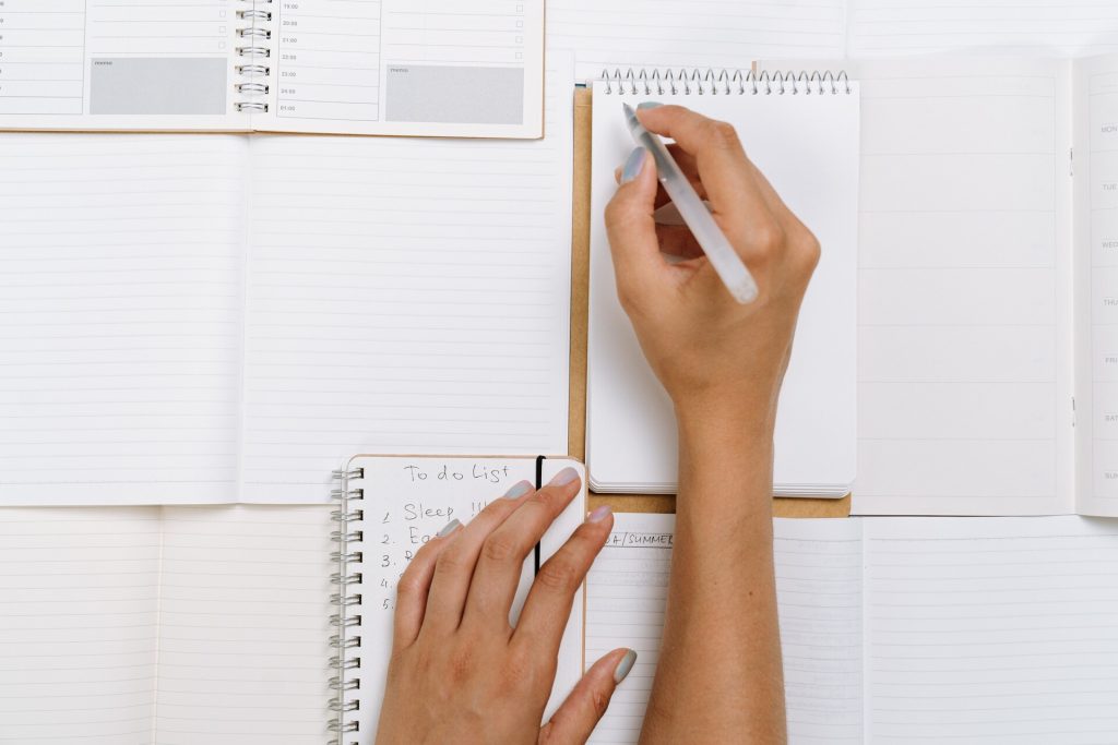 Person writing on notebooks