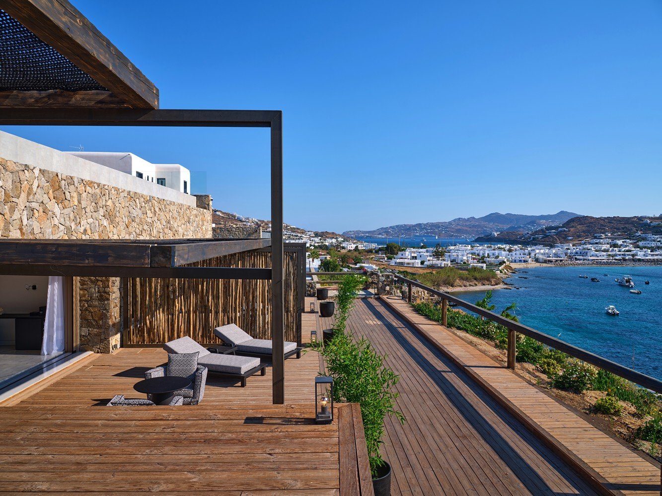 A terrace of a luxury Mykonos villa rental overlooking a beach and the Aegean Sea