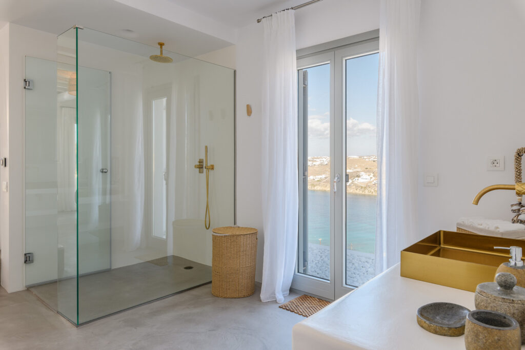 Luxurious bathroom with modern amenities in Mykonos Top Villa, featuring a bathtub with a sea view.