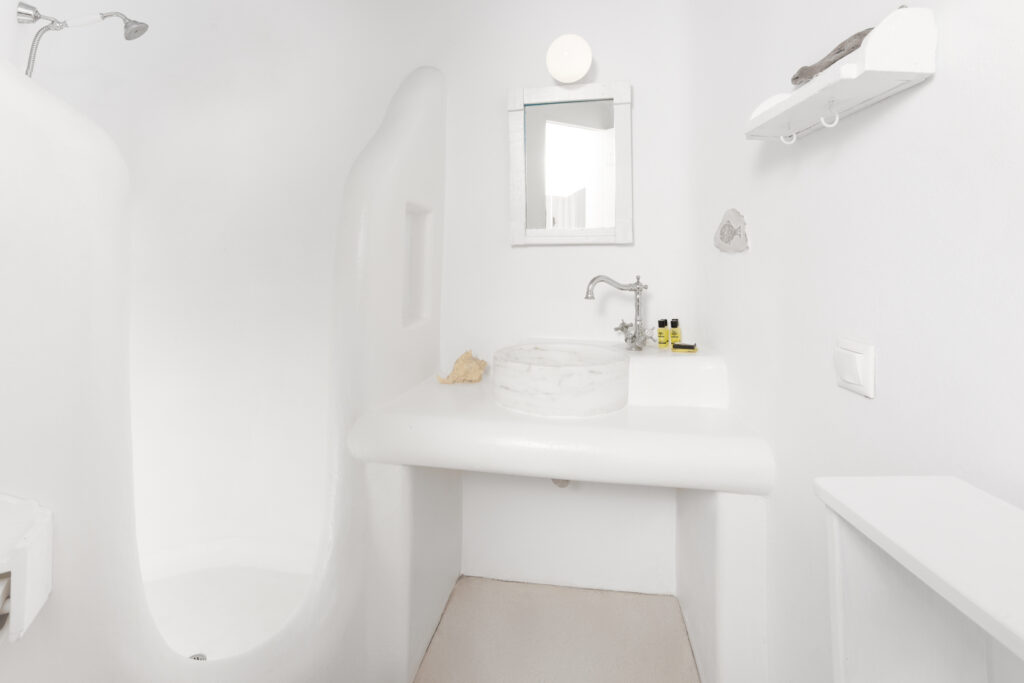 A luxurious bathroom with a spa-like atmosphere, featuring elegant marble countertops, a large sink, a roomy shower area, and a relaxing bathtub, all surrounded by elegant tiles and warm lighting, creating a tranquil space for ultimate relaxation.
