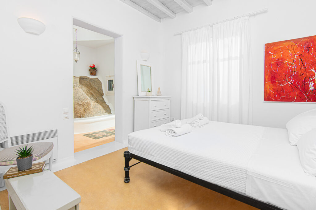 Luxurious bedroom in Mykonos villa, featuring elegant decor and comfortable furnishings.
