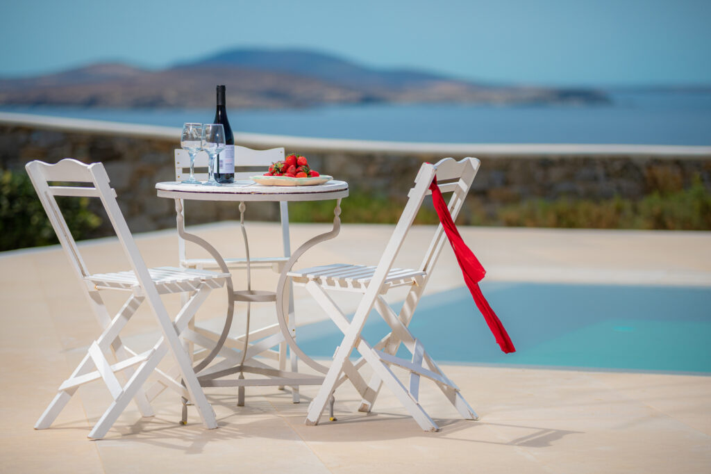 An outdoor terrace of a luxury villa in Mykonos featuring a private pool and lounging area with comfortable furniture.
