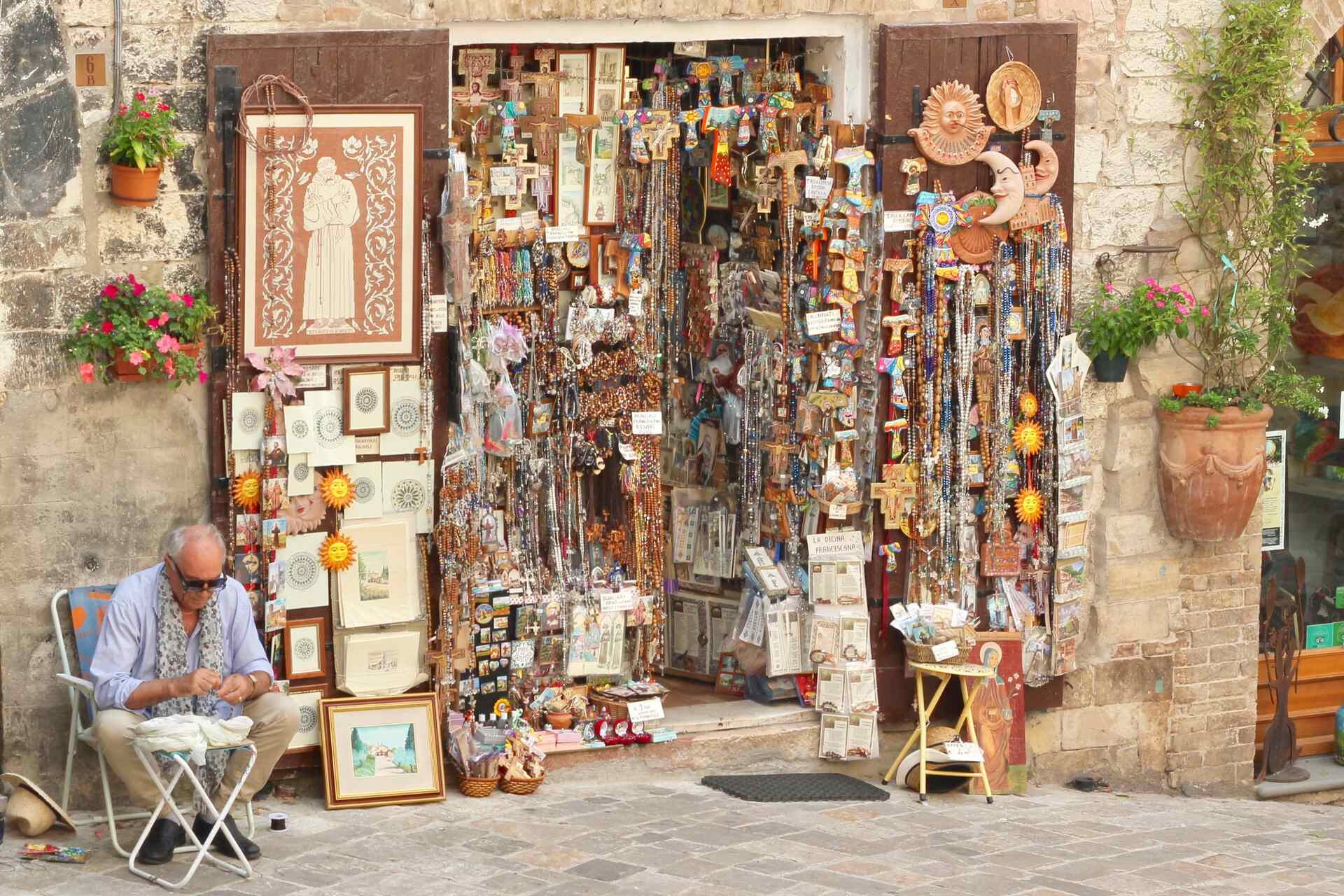 A man sitting in front of a souvenir shop