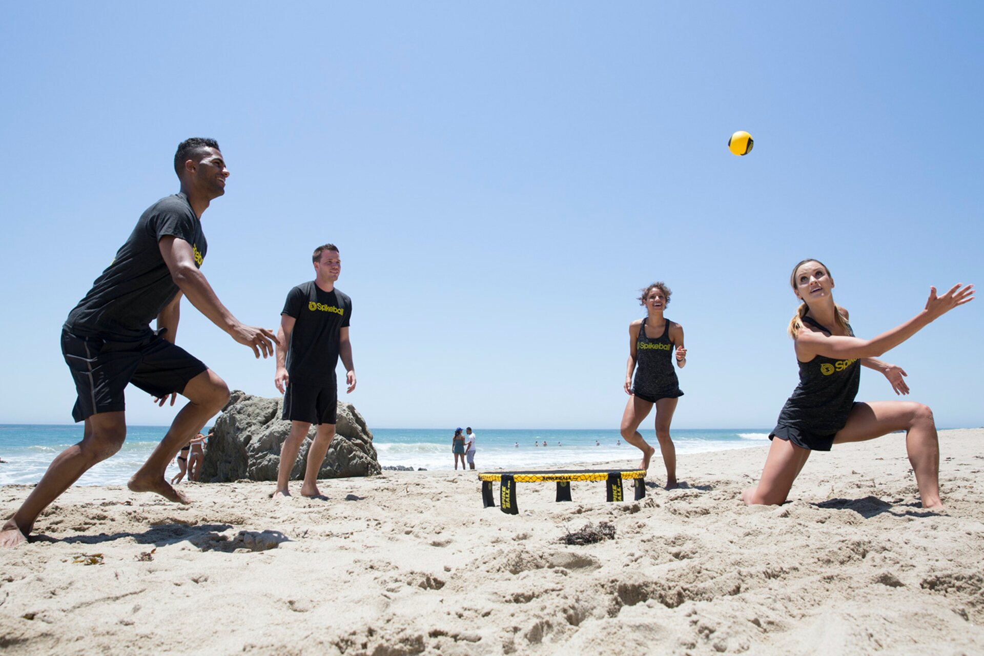 Friends playing a game at the beach, close to the water