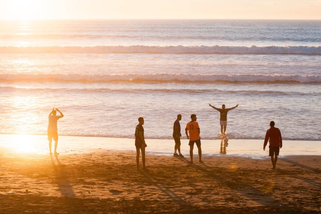A group of friends playing football on the beach