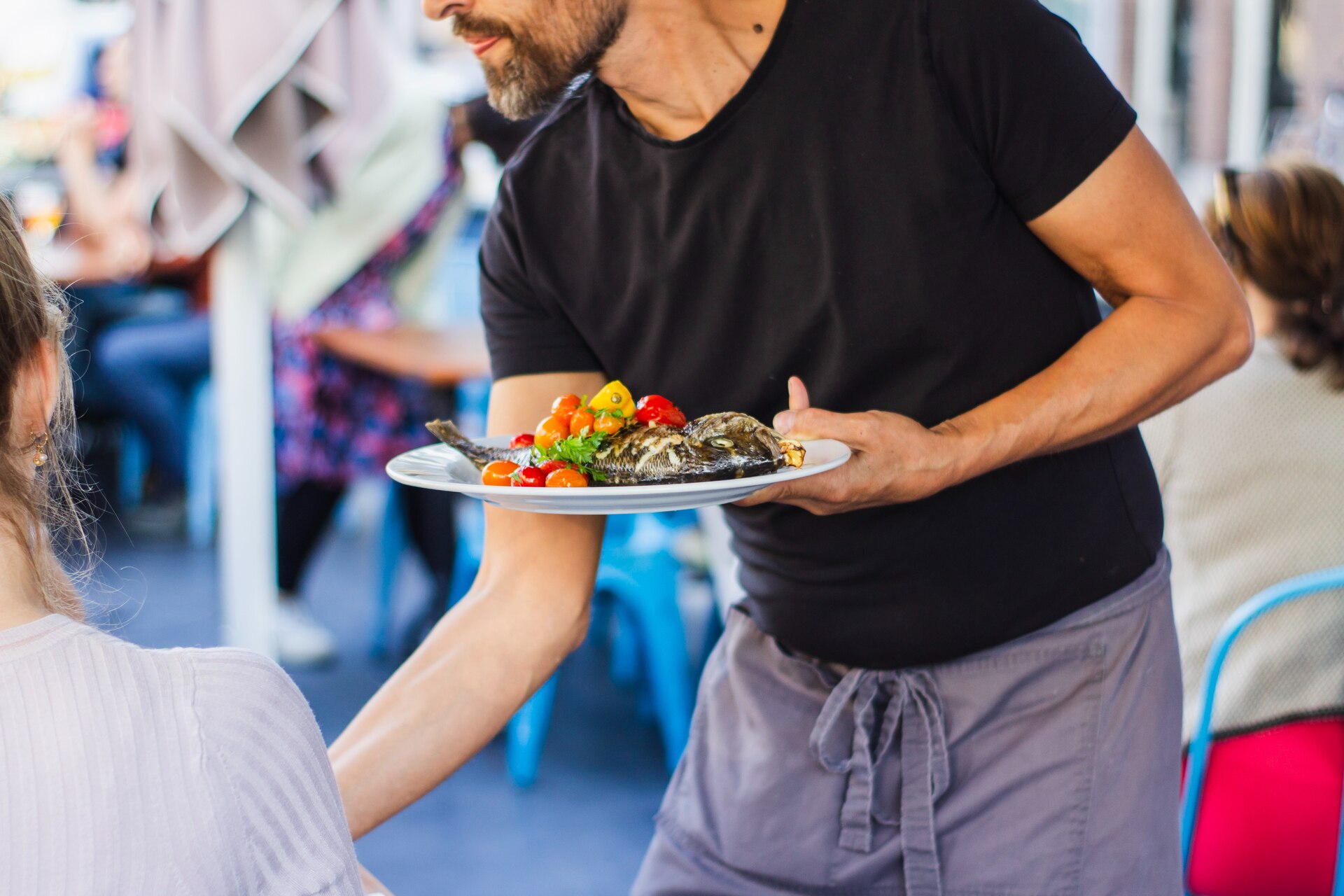 A waiter serving a plate