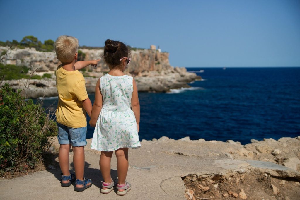 A young girl and a boy by the sea
