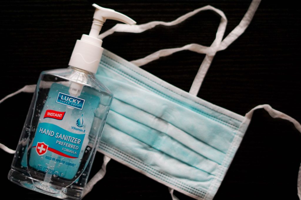 Blue hand sanitizer and a face mask
