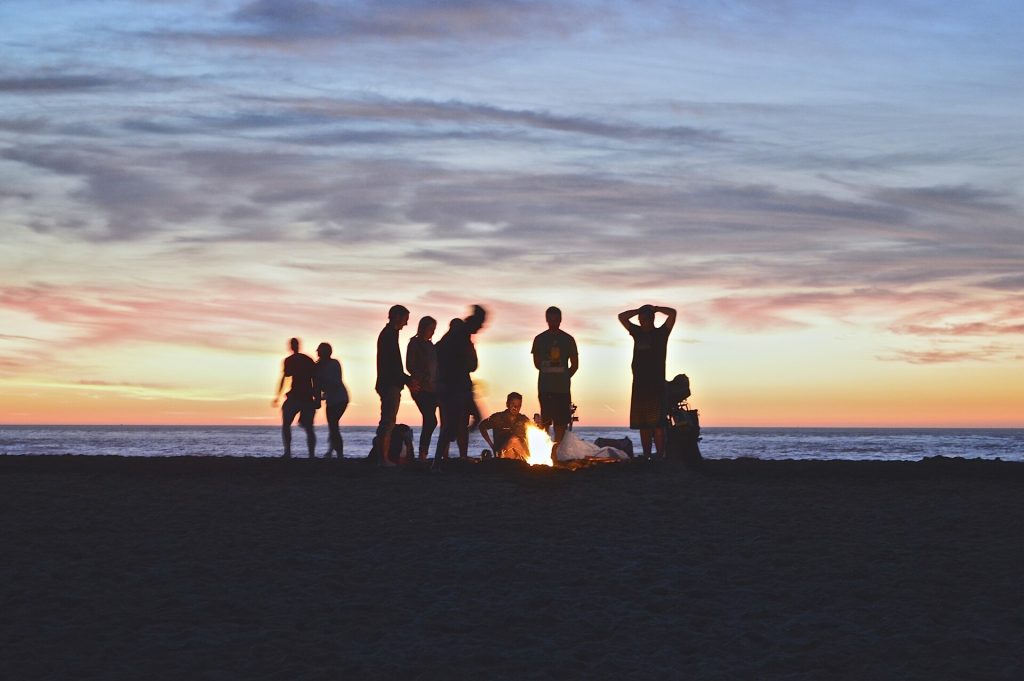 Friends having fun on a beach at sunset