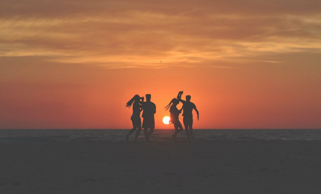 Group of friends dancing on the beach