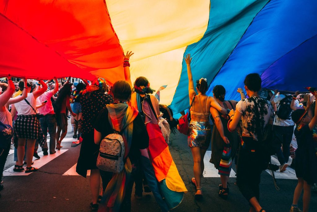 People walking under the rainbow flag