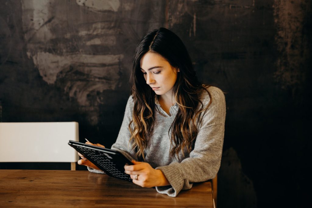 woman sitting at a table and looking at a list