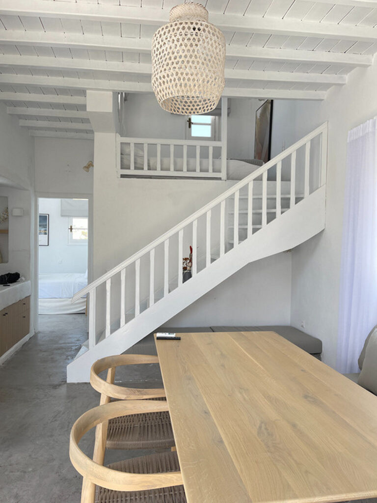 Wooden stairs and table in the dining room of a luxurious Mykonos villa for rent.