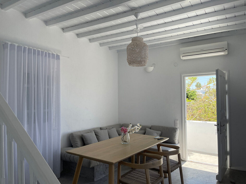 Dining table and comfortable furniture in Mykonos best villa for booking.