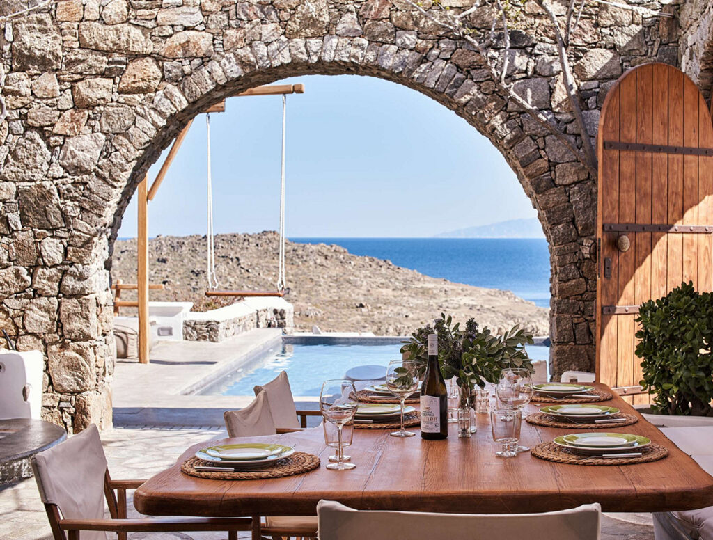 Stunning open area with a lunch table and beautiful sea view in Mykonos top villa for rent.
