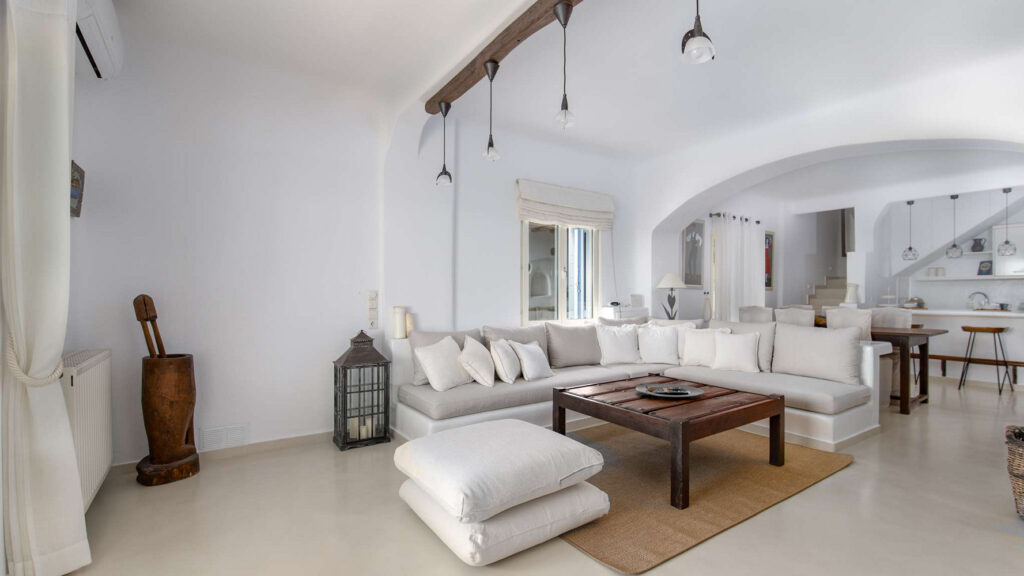 Spacious living room, white walls, and comfortable furniture in the living room of Mykonos best villa for rent.